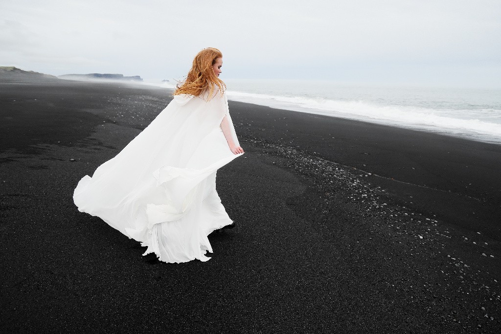 Ženska v beli obleki na obali